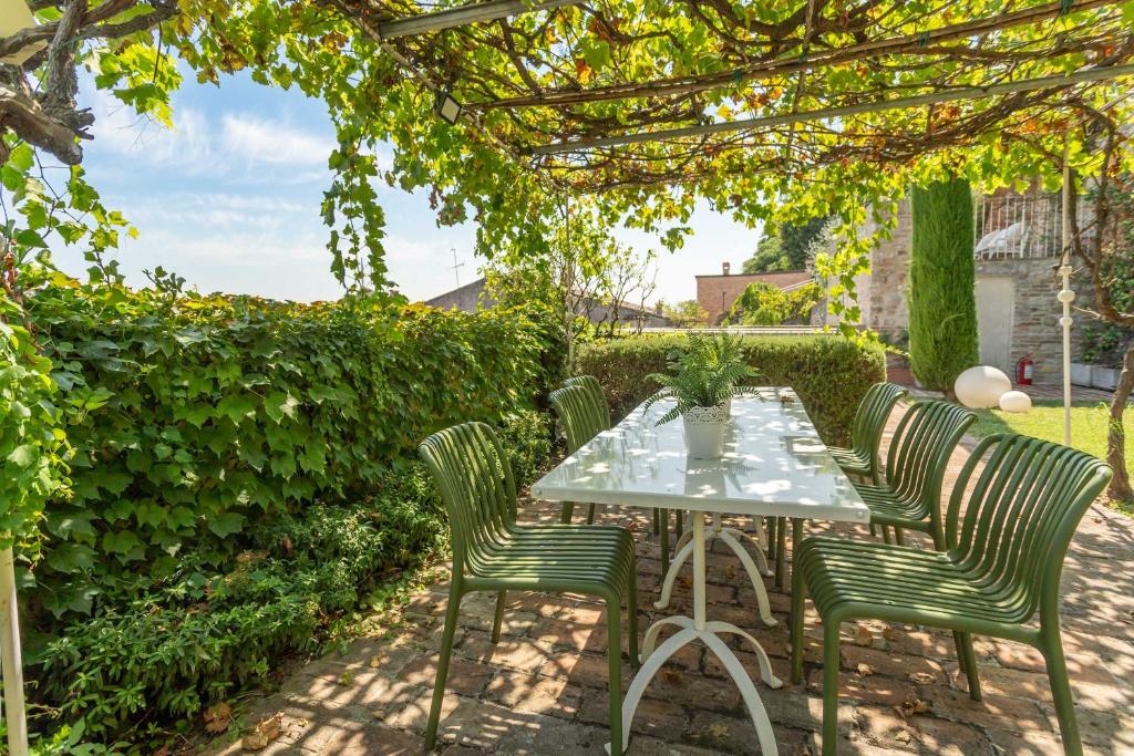 a table and chairs under a pergola at Villa Le Contrade - Rifugio nel Borgo Storico in Santarcangelo di Romagna