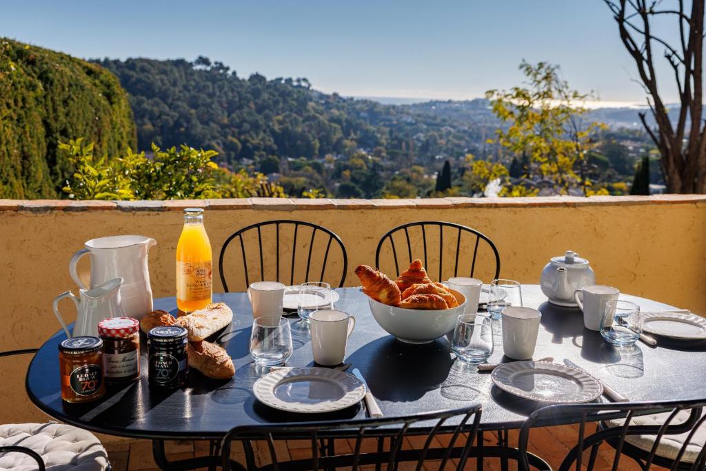 a table with a breakfast of bread and orange juice at Villa Miradou in Saint Paul de Vence