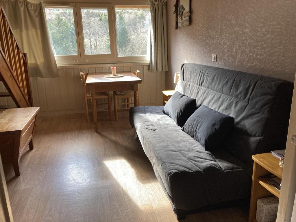 una sala de estar con un sofá y una mesa en Appartement residence bec aigle, en Le Lioran