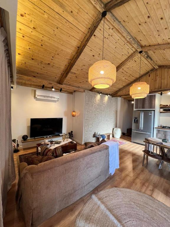 a living room with a large couch and a tv at Hathors Terrace Apartment in Luxor