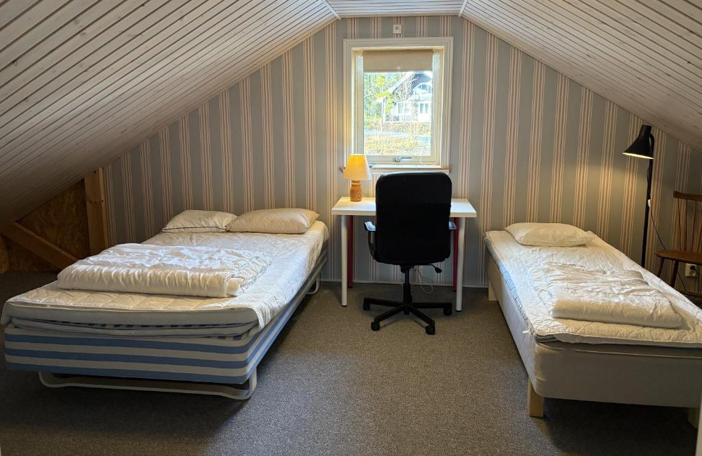 2 Betten in einem Zimmer mit einem Schreibtisch und einem Stuhl in der Unterkunft Mountain Holiday Homes - Ottsjö, Trillevallen -Sweden in Åre