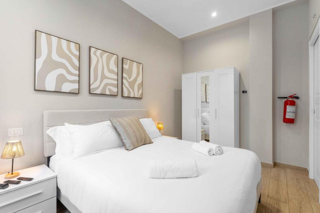 una camera da letto con un letto bianco e tre quadri di Bovisa Appartamento Wi-Fi Ultra Rapido e AC a Milano