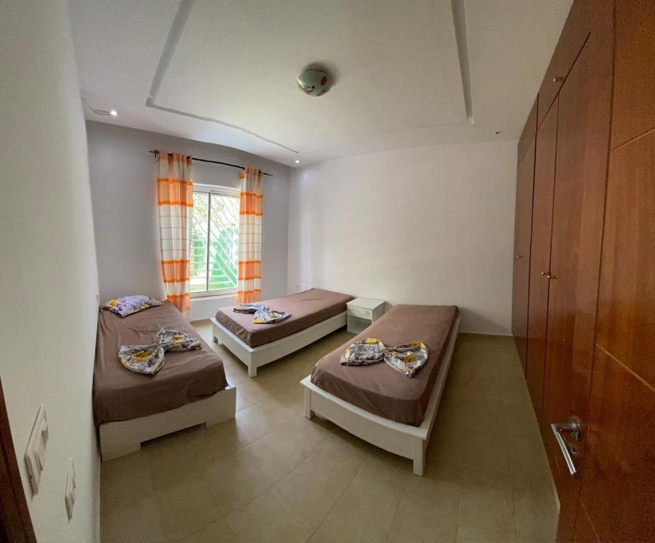 a room with two beds and a window at Rim Apartment , Beachfront in Ḩammām al Ghazzāz