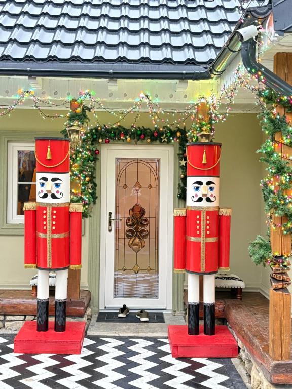 皮亚特拉-尼亚姆茨Barlogul Ursilor Ciubar&BBQ的房子前面摆放着一对胡桃夹子雕像。