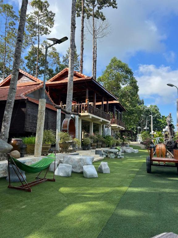 a house with a green lawn and palm trees at Cat Tien Vista in Tân Phú