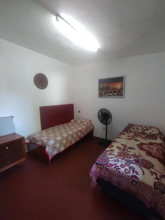 ein Schlafzimmer mit 2 Betten und einer Lampe in der Unterkunft Depto Cura Gaucho in Mina Clavero