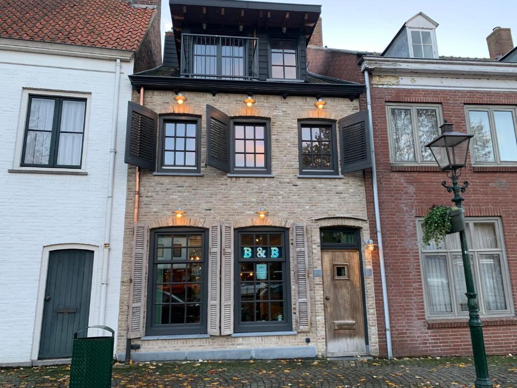 a brick house with black windows and a street light at Herenhuis aan het water in centrum Sluis in Sluis