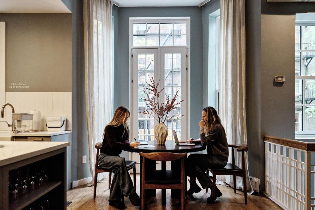 two women sitting at a table in a kitchen at Outsite Chelsea - Work, Connect, Explore in New York