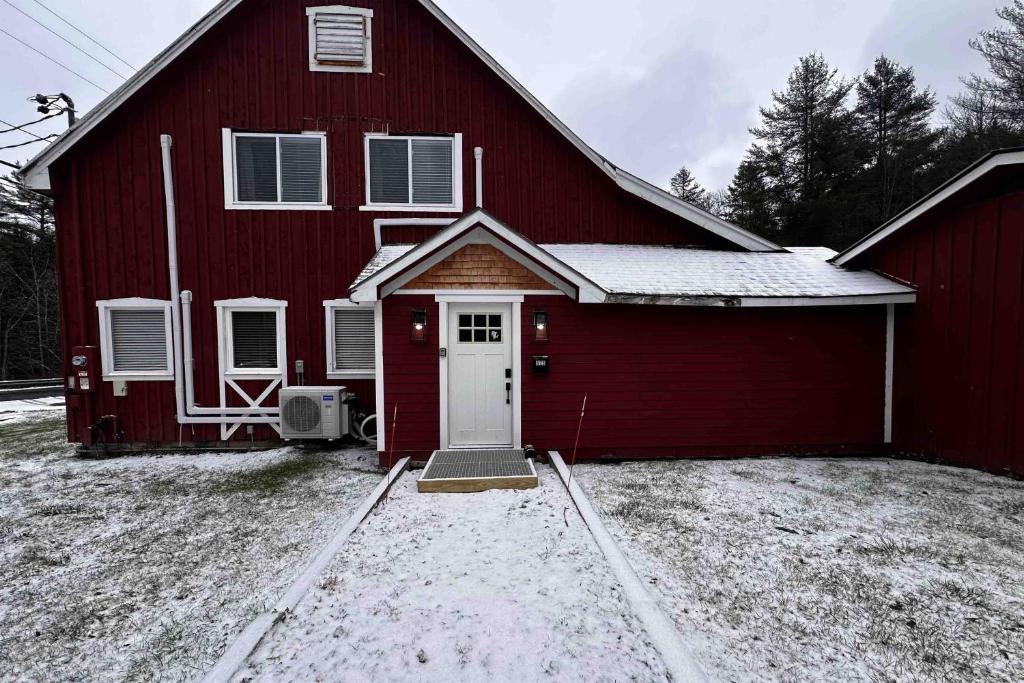 Un fienile rosso con una porta bianca nella neve di Mill Brook Retreat - Unit 1 a Irasville