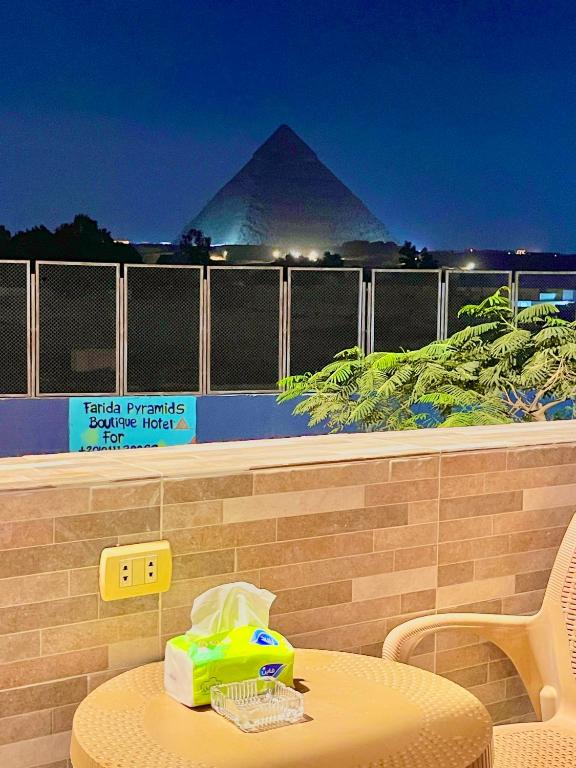 a table and chairs with a pyramid in the background at Farida Pyramid Boutique Hotel in Cairo