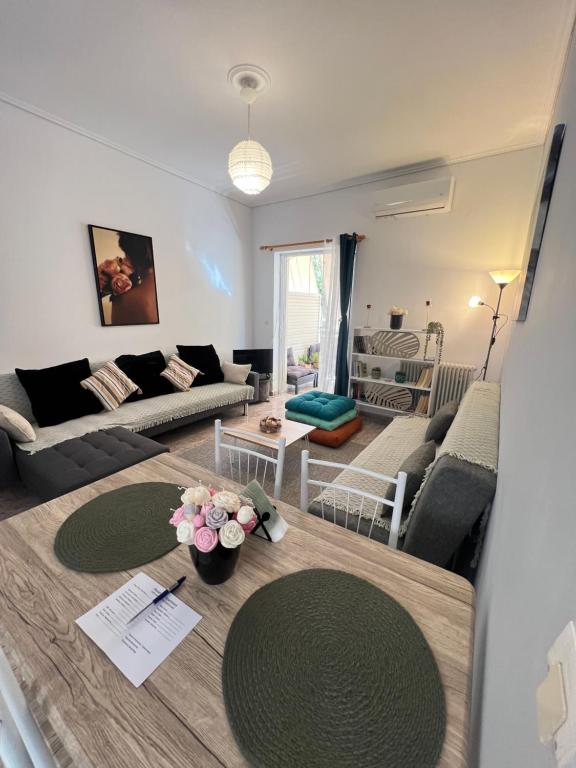 un soggiorno con un tavolo con sopra dei fiori di Alexandra’s apartment a Paralía Akrátas