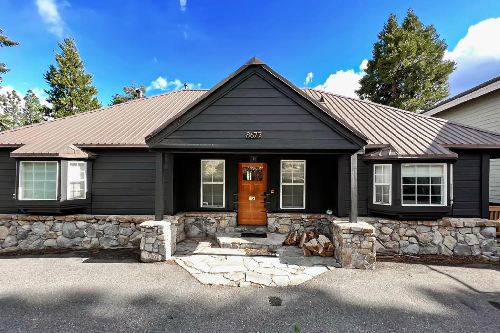 een zwart huis met een stenen muur bij Lakeview Getaway at Rubicon Bay in Rubicon Properties