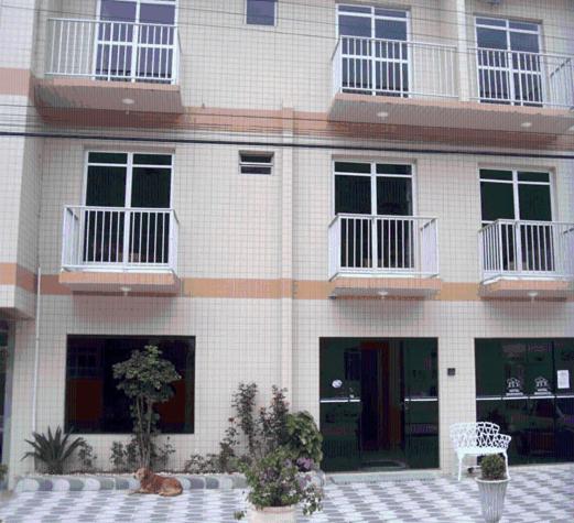 a cat laying in front of a building at Maranata Hotel in Governador Celso Ramos