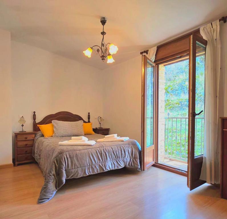 a bedroom with a bed and a large window at Casa Rural Raíces del Alto Tajo in Armallones