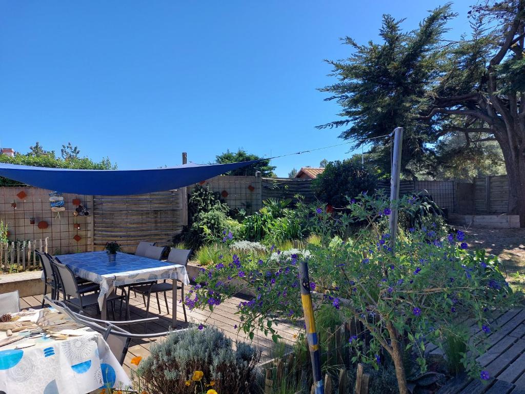 a garden with a table and some plants at Maison 6 personnes in Barbâtre