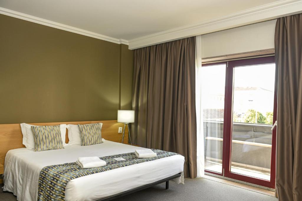 Ένα ή περισσότερα κρεβάτια σε δωμάτιο στο Dom Joao Hotel