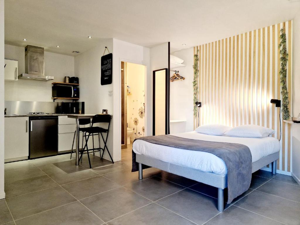 a bedroom with a bed and a small kitchen at SKY - Gîte meublé & confort Drôme - Écolodgîte in Laveyron
