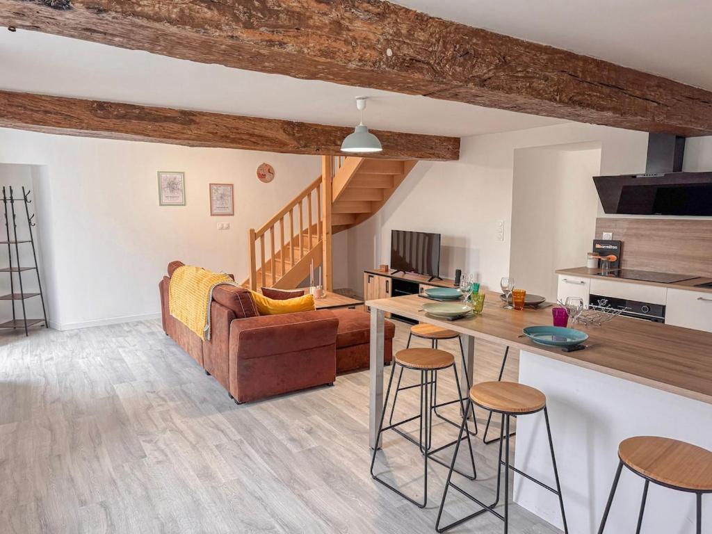 a kitchen and living room with a couch and a table at Entre Bressuire & Thouars- By R&G in Coulonges-Thouarsais