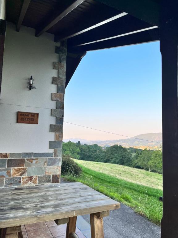 eine Veranda mit einer Holzbank und Blick auf ein Feld in der Unterkunft Casa de Aldea EL ACEBU in Bierces