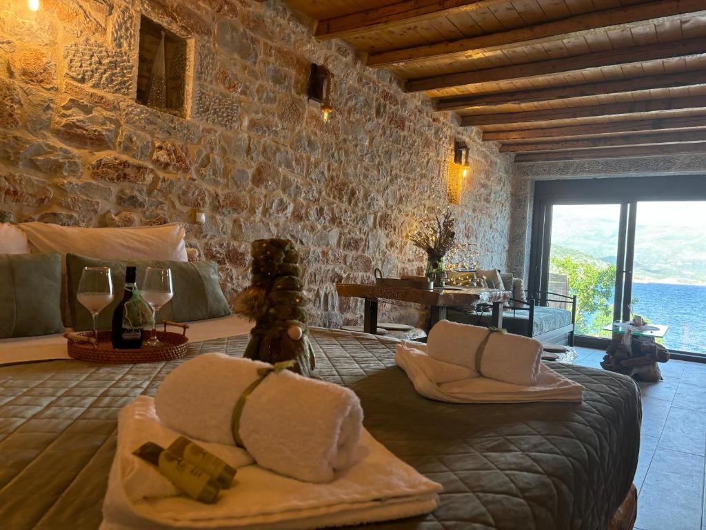 ein Schlafzimmer mit einem Bett und einer Steinwand in der Unterkunft Suite of Villa Lagkadaki in Agriliá