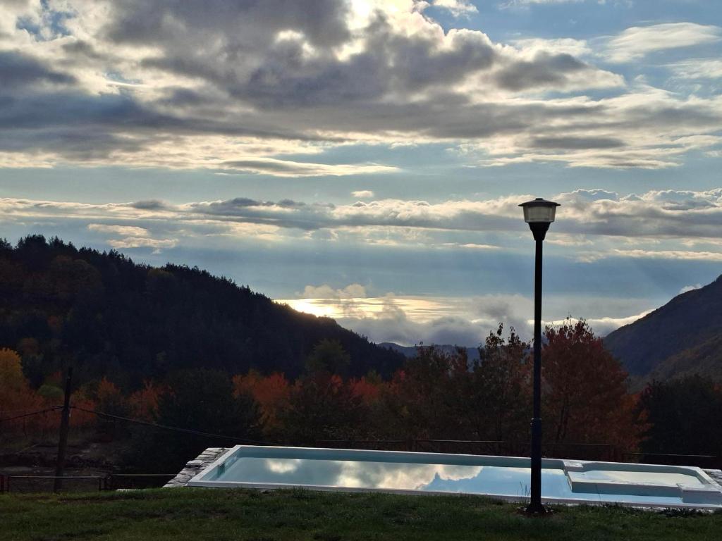 un palo della luce accanto a una piscina con una montagna di Hotel Belica a Struga