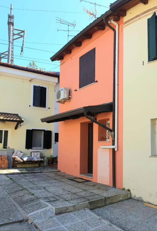 a house with an orange door and a patio at La casa degli Elfi a Monfalcone in Monfalcone