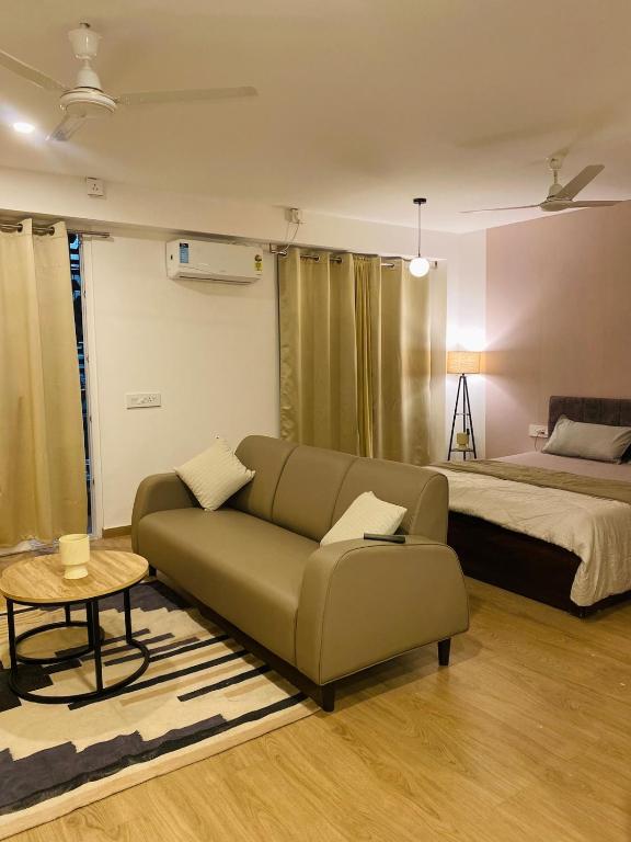 a living room with a couch and a bed at Flat in Viman Nagar in Pune