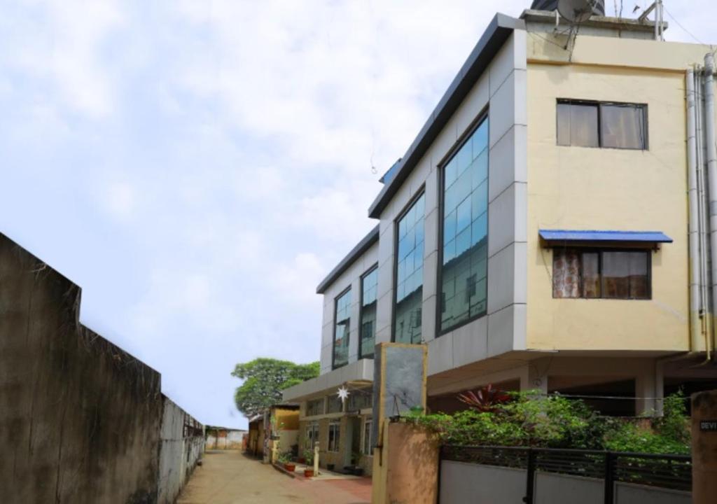 a building with glass windows next to a street at All Seasons Guest House in Trivandrum