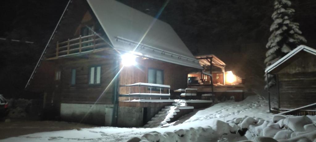 una baita di tronchi nella neve di notte di Lawendowe wzgórze a Pieszyce