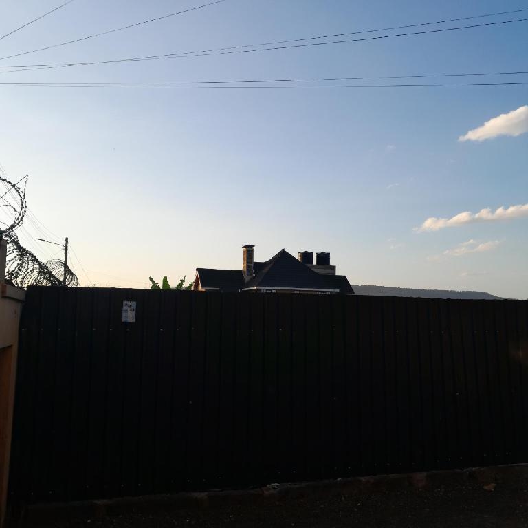 a black fence with a house behind it at Swali residence in Nakuru