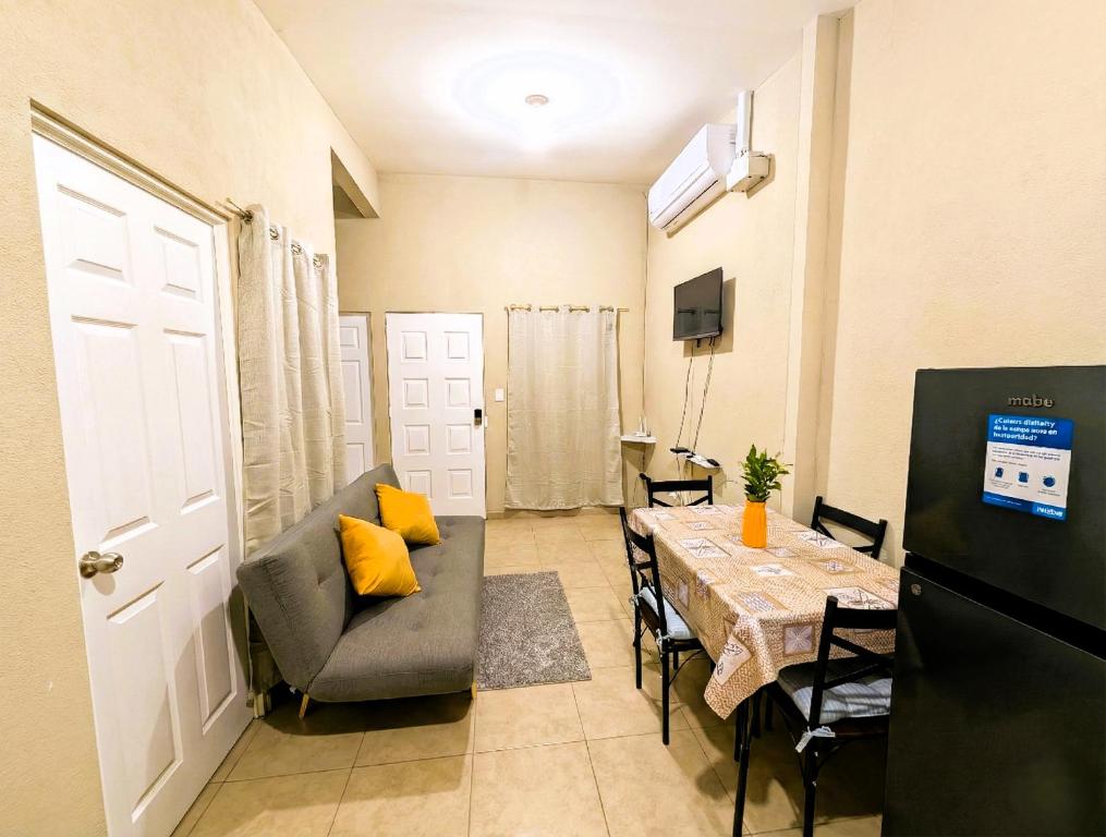 a living room with a table and a couch and a dining room at Via Trip House - Sonsonate in Sonsonate