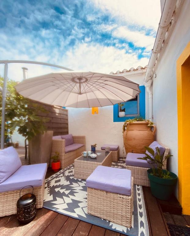 a patio with an umbrella and chairs and a table at Les Bains in La Guérinière