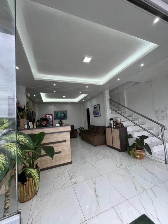 a large living room with a couch and a staircase at Maxi Palace hotel in Capitão Leônidas Marques