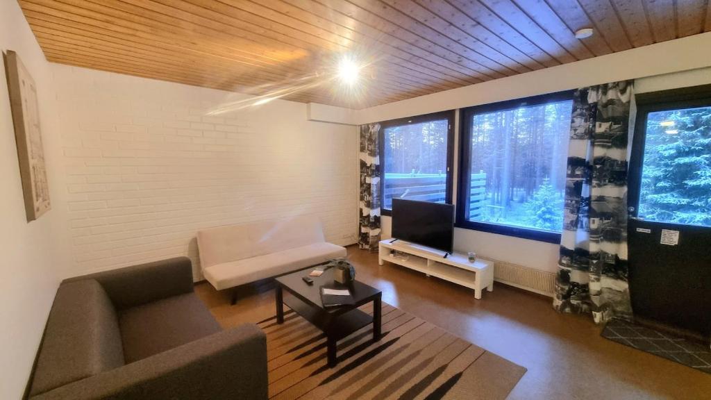 un soggiorno con un divano e una TV di Spacious 4 Bedroom rowhouse a Sodankylä