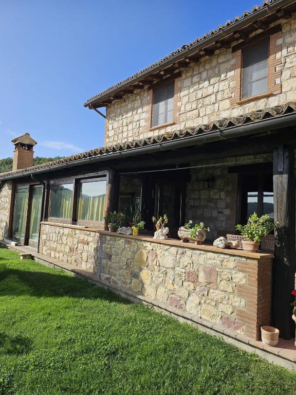 a stone house with plants on a stone wall at Il Casale del Conte in Fratta Todina