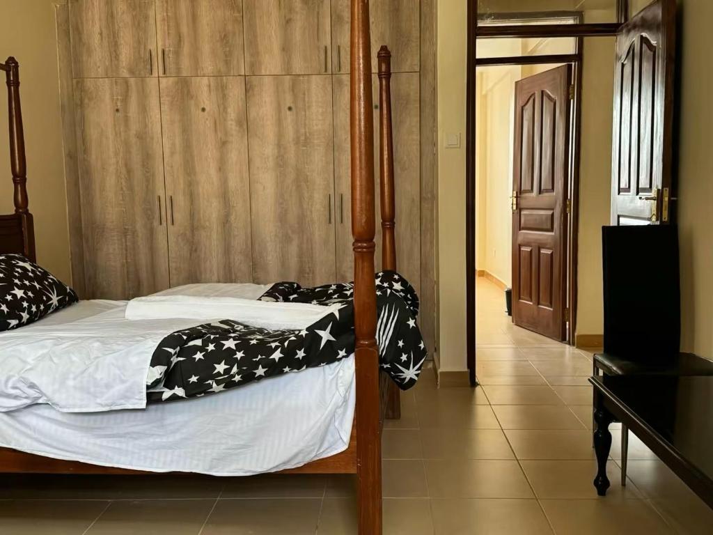 een slaapkamer met een bed met zwarte en witte dekens bij chomama homes in Ngong