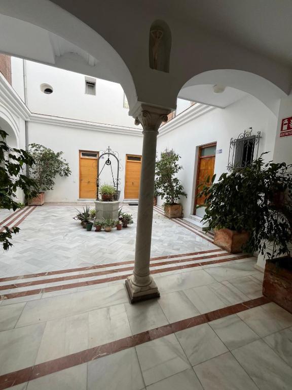 an empty courtyard with a pillar in a building at Casa Palacio Caballeros in Sanlúcar de Barrameda