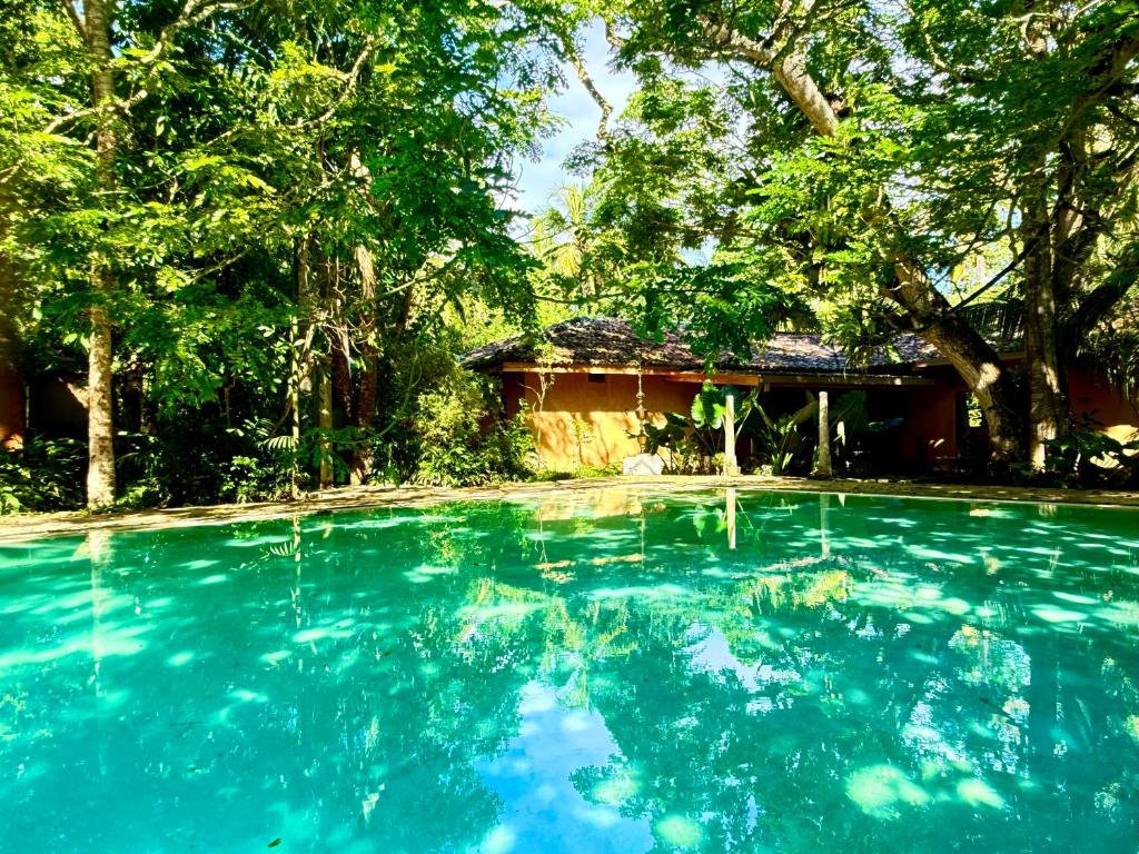una piscina de agua azul frente a una casa en Lotus and Moon, en Habaraduwa Central