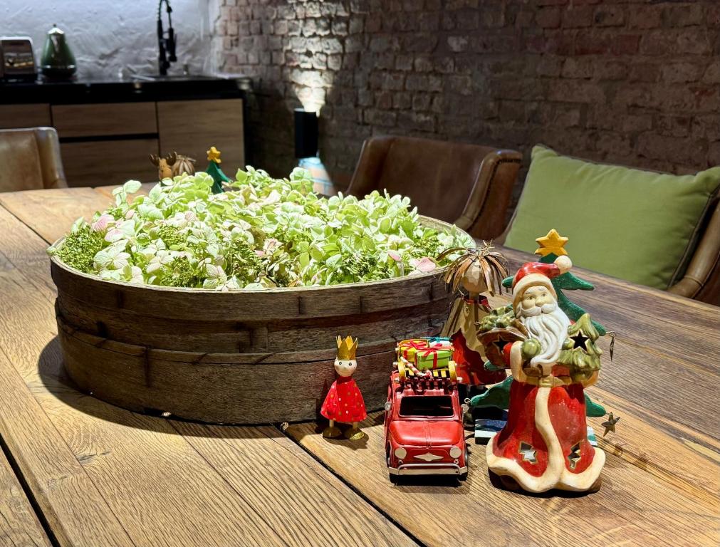 un tavolo con una statuina natalizia accanto a un vaso di verdure di Hotel Zur Linde Dein Self Check In a Michendorf
