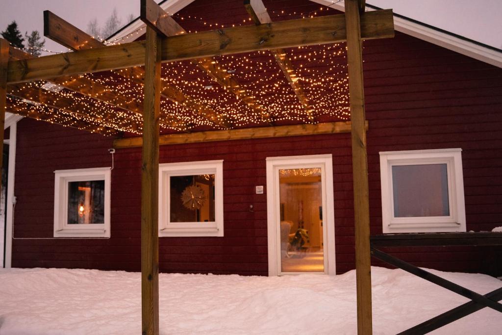 een huis bedekt met kerstverlichting in de sneeuw bij Mukka Mountain 