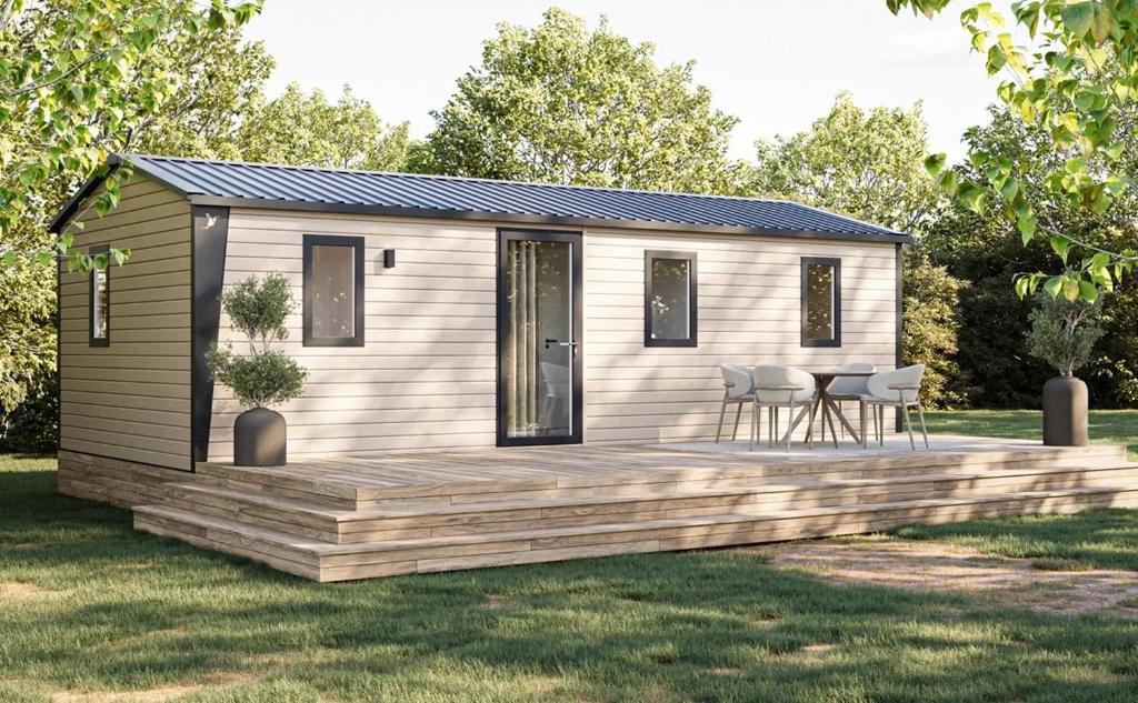 ein winziges Haus mit einer Terrasse im Hof in der Unterkunft Camping 4 étoiles - Parc aquatique - ccbcafh in Jugon Les Lacs