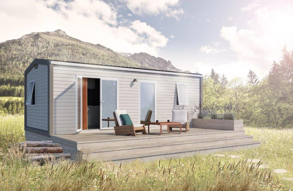 una casa pequeña con terraza en un campo en Camping 4 étoiles - ccbcagb, en Le Gillieux