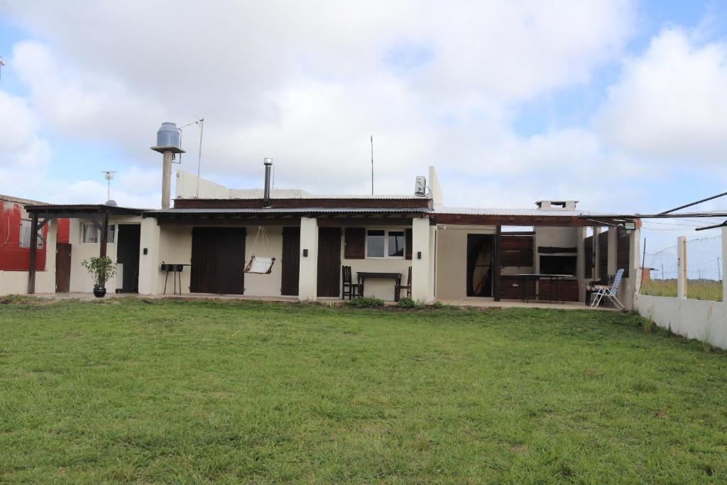 a house with a grass yard in front of it at Casa Slide en Chapadmalal in Colonia Chapadmalal