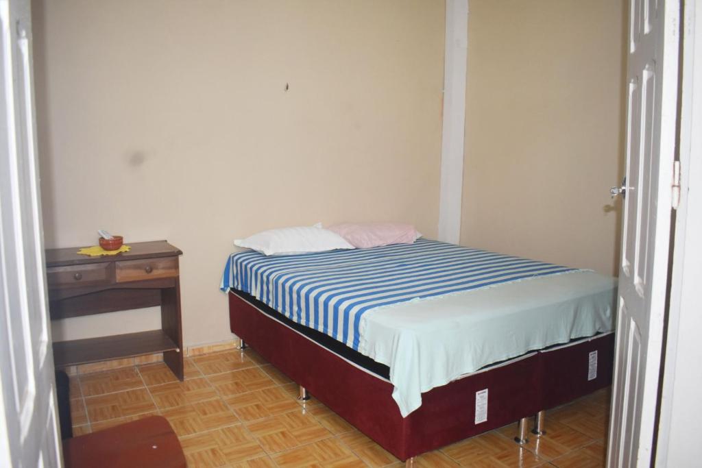 a small bedroom with a bed and a table at Palacete Carmen in Belém