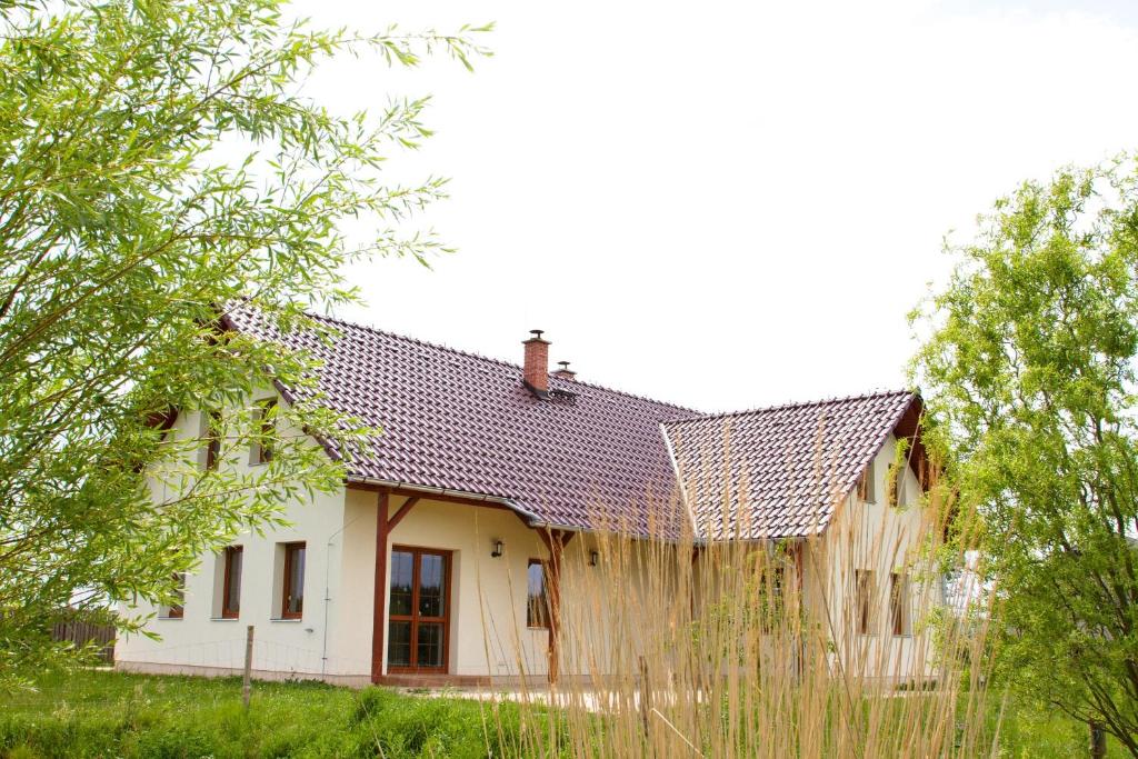 une maison avec une clôture en bois devant elle dans l'établissement Penzion Recall, à Troskovice