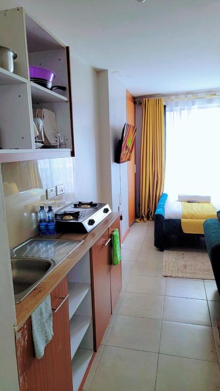 una cucina con lavandino e una camera con letto di Comfy Homes By Becca a Nairobi