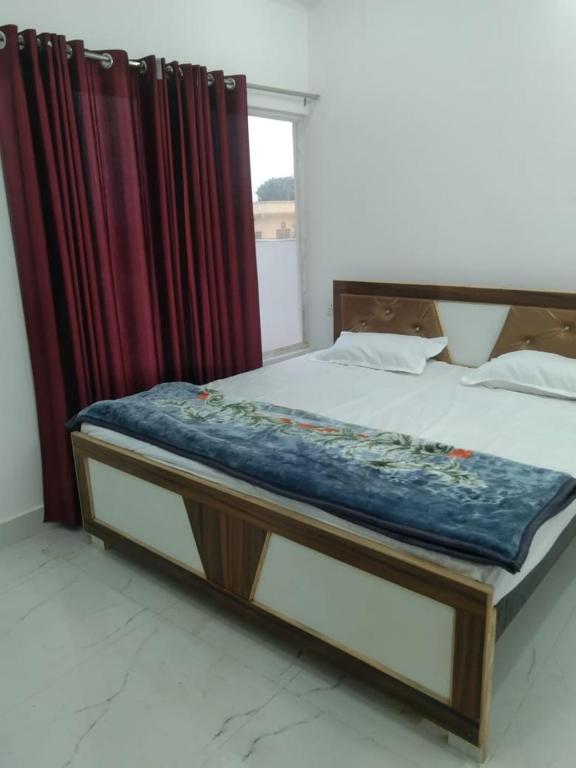 a bed in a room with curtains and a bed sidx sidx sidx at Naimisharanya Atithi Bhavan in Naimishāranya