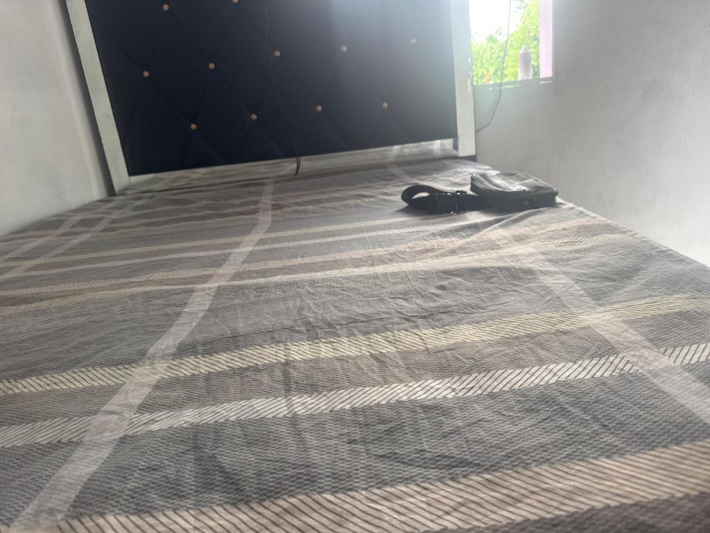 4LoyaltyRecords2storeyQueensuite في كينغستون: سرير مع حقيبة موضوعة على الأرض