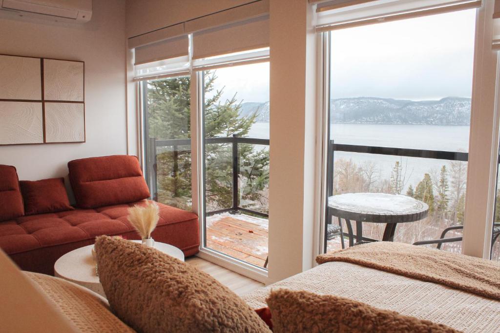 a living room with a couch and a large window at Refuge du Fjord in Saguenay