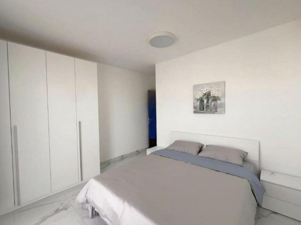 a white bedroom with a bed and white cabinets at B&b flats in Wrocław